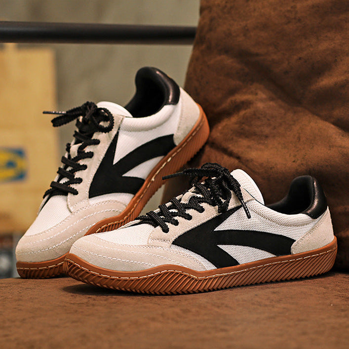 White sneakers with black and brown accents on a wooden surface