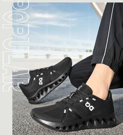 A person wearing black On running shoes with a distinctive wavy sole, shown in a lifestyle outdoor setting with a blurred background of water and sky.